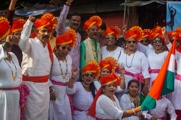 People in orange turbans celebrating with indian flag